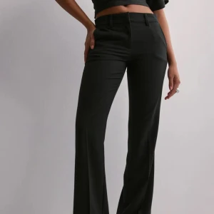 Svarta kostymbyxor - Snygga svarta kostymbyxor med bootcut. Byxorna har låg midja,Perfekta för en stilren look och lätta att matcha med olika toppar och skor. Säljer pågrund av att de är för stora på mig. 