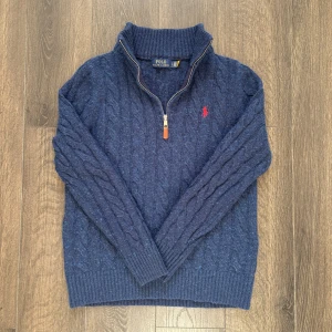 Stickad Polo Ralph Lauren - Säljer en riktigt fin stickad Quarter zip av Polo Ralph Lauren i mycket bra skick.  Storlek S, men har krympts lite i tvätten.  En skön tröja som passar nu till hösten 🍂 och vintern ❄️  Längd: 60cm Axelbredd: 38cm  Hör av er vid fler funderingar!