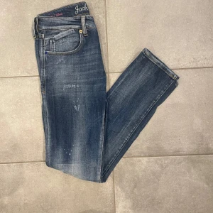 Blå jeans från Jack & Jones - Snygga blå jeans från Jack & Jones med en klassisk femficksdesign. De har en lätt slitning för en cool look och är designade i Italien. Perfekta för en avslappnad stil. Det ör en limited edition modell som inte tillverkas längre så de ör rätt svåra att få tag i.