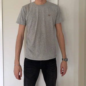 Grå Moncler t-shirt i bomull - Snygg grå t-shirt från Moncler med klassisk rund hals och korta ärmar. Diskret Moncler-logga på bröstet. Mjuk och skön bomullskvalitet som passar perfekt till jeans eller shorts. Enkel och stilren design för en clean look.