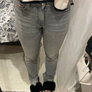 Grå straight jeans - Snygga grå jeans från Zara i storlek 36 med klassisk femficksdesign och raka ben. Jeansen har en normal passform och är tillverkade i mjukt jeanstyg med subtila slitningar. Perfekt för dig som gillar en enkel och stilren look.