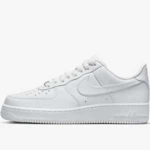 Nike Air Force 1 vita sneakers - Klassiska Nike Air Force 1 sneakers i helvitt skinn med låg profil och rund tå. Skorna har snörning, perforerade detaljer på tån och den ikoniska swoosh-loggan på sidan. Perfekta för en clean och stilren look.