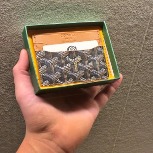  korthållare i brunt och svart - Snygg svart/brun korthållare med ikoniskt mönster och flera kortfack. Tillverkad i skinn material och  Perfekt för dig som vill ha något både stilrent och unikt i fickan.