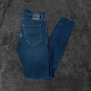 Replay jeans hyperflex - Snygga blå jeans från Replay med klassisk femficksdesign och diskreta slitningar. Jeansen har slim fit-passform, normal midja och raka ben. Tillverkade i mjukt denimtyg med stretch för extra komfort. Perfekta för dig som gillar stilrena och bekväma jeans.