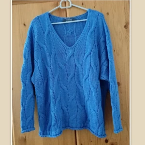 Blå stickad tröja från Primark, L - Säljer en blå stickad tröja från Primark med snyggt kabelstickat mönster och v-ringad hals. Tröjan har lång ärm och en relaxed fit som är perfekt för lager-på-lager. Storlek M/L.  Storlek M, men stor i storleken. Det passar storlek L. Anväd bara en gång. Från armhålan till armhålan65cm,längd 68cm
