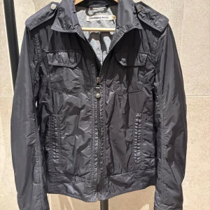 Svart jacka från J.Lindeberg - Svart stilren jacka från J.Lindeberg. Storlek M, fint skick. Hör av er om ni har några funderingar. Priset är ej hugget i sten.