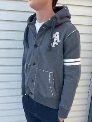 Abercrombie & Fitch kofta - Tja! Säljer nu denna sjukt snygga abercrombie& Fitch kofta. Skick 8.5/10 riktigt bra utan synliga defekter. Modellen är 181 men passar allt mellan 169-180. Hör av er vid minsta lilla funder!