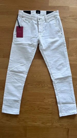 Vita jeans från Tramarossa - Snygga vita jeans från Tramarossa  med raka ben och klassisk femficksdesign. Jeansen har bälteshällor, silverfärgade knappar och är tillverkade i ett mjukt bomullsmaterial med lite stretch för extra komfort.