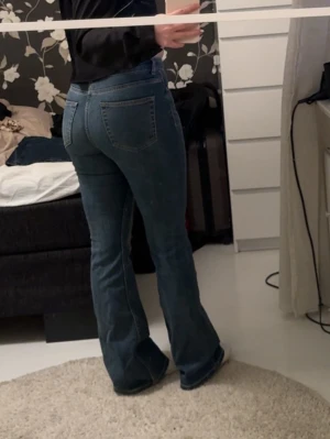 Blå bootcut jeans med hög midja - Säljer ett par blå bootcut jeans med hög midja från H&M, fake fickor där fram men inte bak. Lite små för mig vid magen och rumpan och jag är vanligtvis 36 så kanske passar mer en 34. 