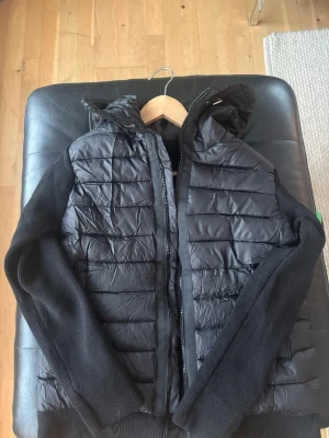 Svart moncler cardigan  - Svart moncler cardigan med quiltat mönster och huva. Helt ny och inga minus om den. Dragkedja framtill och två fickor. Perfekt för kalla vinter och sommardagar.