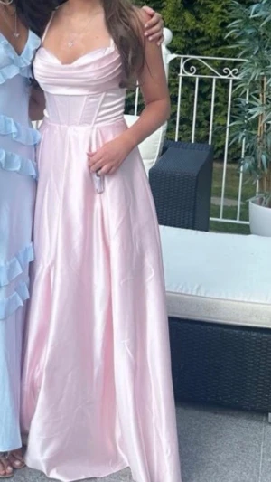 Ljusrosa axelbandslös balklänning - Säljer nu denna så så vackra rosa balklänning. Den har fickor som inte syns men så smart och praktiskt. Den har knyte med kors i ryggen och går därav att justera. Den är använd 1 gång.💞