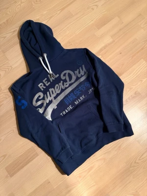 Superdry hoodie - Riktigt fet superdry hoodie för riktigt bra pris. Det finns inga skavanker eller liknande på tröjan och den är i storlek S men skulle kunna passa någon med M. Vid frågor om bilder eller liknande är det bara att fråga😄💛