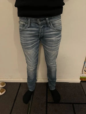 Slim fit ljusblå jeans med slitningar - Säljer ett par slim fit ljusblå jeans med snygga slitningar och tvättade detaljer. Jeansen har klassisk femficksdesign och smal passform hela vägen ner. Perfekta för dig som gillar en modern och avslappnad stil.  Storleken är 30/32. Modellen är 180 cm lång och väger 64 kg. Det är bara att höra av sig vid frågor och funderingar 😀