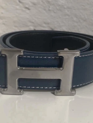 Hermes bälte (helt nytt) - Säljer detta sprillans nya Hermes bältet i marinblå färg, det går även att vända på spännet till svart sida om du skulle vilja det! Kontakta mig via funderingar.