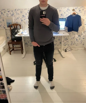 Mörkgrå stickad tröja från Pier One - Snygg mörkgrå stickad tröja från Pier One med rund halsringning och ribbade muddar vid ärmslut och nederkant. Perfekt för lager-på-lager och enkel att matcha med jeans eller chinos. Klassisk och stilren modell som funkar året runt.