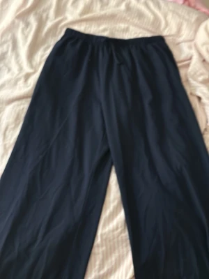 Marinblå linnebyxor Stradivarius - Snygga marinblå linnebyxor från Stradivarius med avslappnad passform och resår i midjan. Perfekta för en chill och stilren look. Tillverkade i lätt och luftigt material som passar perfekt till sommaren. Köpta i Spanien. 