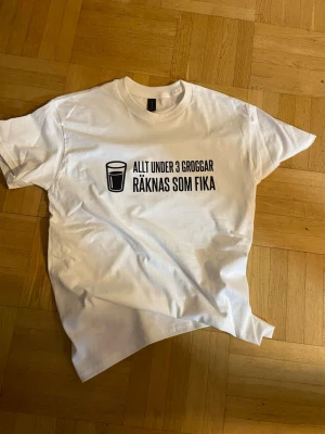 Rolig T-Shirt med trycket ”Allt under 3 groggar räknas som fika” - T-shirt med trycket ”Allt under 3 Groggar räknas som fika” Finns också tillgänglig i Storlekar från S-5XL  Finns också tillgänglig i flera färger  *Storleken är lite större än normalt men kräver inte att man går ned en storlek  🔗 Hitta mer på tryckxpressen.se