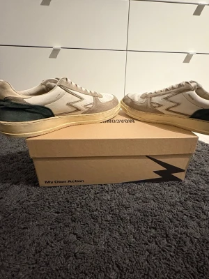 Beige och vita sneakers från MOA Concept - Snygga sneakers från MOA Concept köpta på NK, göteborg. Nypris 2500 kr. Storleken är 43, men är stor i storleken. Passar därför 44 perfekt! Pris kan diskuteras, hör av dig vid minsta fråga!