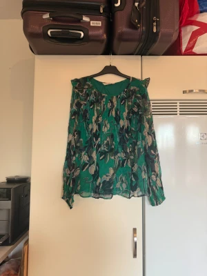 Odd molly topp - Säljer en superfin grön långärmad topp med fina detaljer i svart och beige. Från märket Odd Molly. Storlek 2 som enligt deras storleksguide motsvarar en M. Mycket fint skick, jag hittar inga synliga anmärkningar eller defekter. 