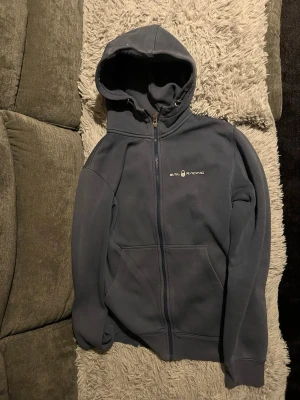 Sail Racing tröja  - Stilren och bekväm blå huvtröja från Sail Racing.