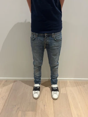 Nudie Jeans - Ett par feta ljus blåa nudie jeans i modellen ”grim tim”! Storlek är ”W27  L32” Skriv vid minsta fundering! Har dock blivigt sydda på båda knäskålarna och vid skrevet men skrevet synignen syns inte när man har på sig dom!