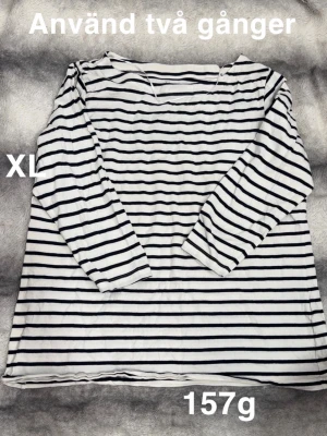 Randig långärmad topp XL - Säljer en vit och svart randig långärmad topp i storlek XL. Toppen har klassiska horisontella ränder, perfekt för en chill och avslappnad stil. Passformen är normal och materialet känns skönt mot huden.🌸 Använd två gånger. Trekvartsärm. Storlek XL