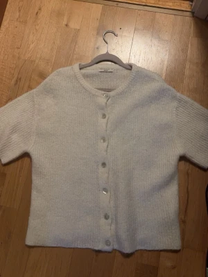 Vit stickad kofta från Gina tricot  - Jättesnygg stickad kortärmad tröja från Gina tricot med knappar! 