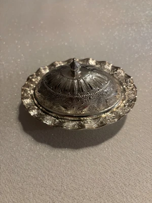 Liten fin ask med avtagbart lock. - Liten fin ask i silvrigt material med avtagbart lock.Kan andvändast till förvaring till smycke eller vad som helst.