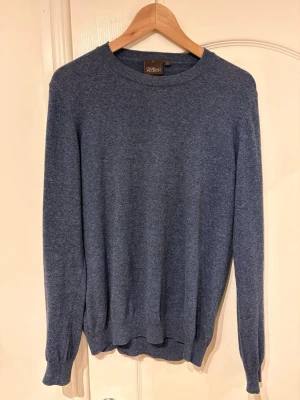 Blå stickad tröja från Oscar Jacobson - Mjuk och stilren blå stickad tröja från Oscar Jacobson. Använd fåtal gånger nypris ca 1500