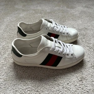 Gucci ’Ace’ sneakers | 40 - Säljer dessa Gucci ’Ace’ skorna till ruggit bra pris! | Size: US6, motsvarar 40-41. | Creasing och heeldrag förekommer men skorna har ett fint helhetsintryck. | Bara skorna ingår | Bara att höra av dig vid minsta fråga eller fundering!