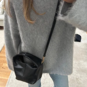 Svart väska - Söt liten svart väska från Nelly. Väl använd så defekter förekommer men inget som påverkar helheten. Skriv för fler bilder