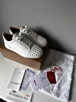 Christian Louboutin vit - Helt nya Christian Louboutin i svart färg med nitar. Fräschiga stiliga skor speciellt med de nitar och röd sula. Storlek 42