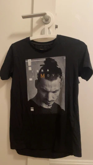 Ibrahimovic t-shirt - Cool svart t-shirt från A-Z med grafiskt tryck av Zlatan Ibrahimovic på framsidan. T-shirten har rund hals och korta ärmar, med vit och gul text i designen. Perfekt för dig som gillar sport och streetwear. Väldigt fin tröja för svenska fansen, en t-shirt som jag rekommenderar men är för liten för mig nu. Den är i storlek 158-164