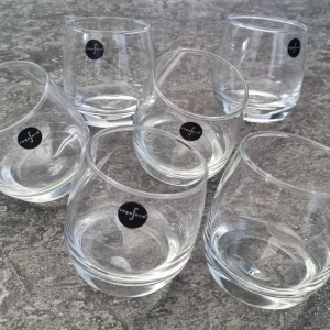 Sagaform whiskeyglas - Säljer ett set med fem whiskeyglas från Sagaform. De är runda i botten som gör dem extra snygga på bordet. Tillverkade i transparent glas med Sagaform-logga på varje glas. Perfekta för att ge din dukning en fräsch vibe.Obs! Sex glas på bild men detta är 5 glas. Ett har gått sönder.