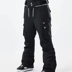 Svarta byxor från Dope  - Svarta snowboard/skid byxor från Dope Snow med hög midja, breda ben och flera fickor. Byxorna har vita snören i midjan, knappar framtill och förstärkta detaljer. Perfekta för vintern och outdoor-aktiviteter. Finns inga synliga defekter. Ordinarie pris 1799kr.