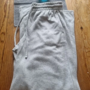 Ljusgrå mjukisbyxor med snörning - Superbekväma ljusgrå mjukisbyxor med elastisk midja och snörning. Perfekta för chill dagar eller när du vill ha det extra soft. Tillverkade i mjukt bomullsmaterial och har fickor på sidorna.