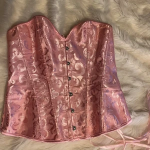 Rosa korsett - Rosa korsett från Temu i storlek s men kan passar de flesta då den har snörning där bak. Använd endast en gång.
