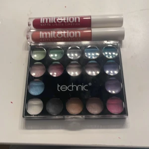 Technic ögonskuggspalett & 2 Imit8tion läppstift - Säljer en Technic ögonskuggspalett med 17 färger i allt från grönt, blått, lila, rosa, guld till svart och vitt. Medföljer två Imit8tion matte liquid lipstick i nyanserna mörkröd och nude/ljusbrun. Perfekt för dig som gillar att experimentera med färg och matta läppar.