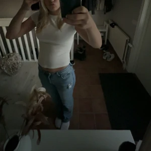 Blås jeans från Gina tricot - Säljer ett par blå jeans med rak passform och en snygg slitning på ena låret. Jeansen har klassisk femficksdesign och normal midja. Perfekta till en avslappnad stil och passar till det mesta. Materialet är jeans och färgen är ljusblå.