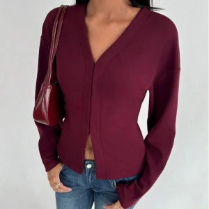 Vinröd v-ringad långärmad tröja - Pris kan diskuteras❤️ Säljer en vinröd långärmad tröja med v-ringning och figurnära passform. Tröjan har en stilren design utan synliga knappar eller dragkedja och är perfekt att matcha med jeans. Materialet känns mjukt och stretchigt.