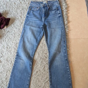 Blå jeans - Säljer ett par klassiska blå jeans från g perfect jeans i storlek 34. Jeansen har raka ben, fem fickor och hög midja. Tillverkade i bomull med snygg tvättad finish och kontrastsömmar. Perfekta till sneakers eller boots.