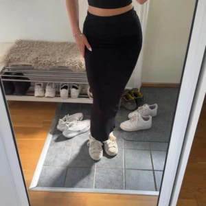Svart långkjol från Gina Tricot - Säljer en svart långkjol från Gina Tricot i storlek S. Kjolen har en tight passform och snygg rynkning längs sidan. Materialet är mjukt och stretchigt. 