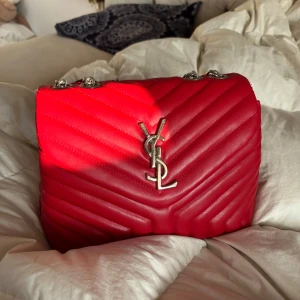 Röd YSL axelväska i skinn - Snygg röd axelväska i quiltat skinn med silverfärgade kedjor.