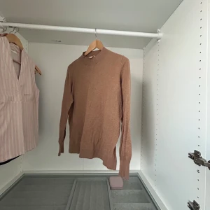 Beige stickad tröja från Dranella - Säljer en beige stickad tröja från Dranella i storlek S. Tröjan har lång ärm, ribbade muddar och en högre rund halsringning. Perfekt för dig som gillar en enkel och stilren look med mjukt material.