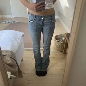 Bootcut jeans från Bershka ljusblå - Säljer ett par snygga ljusblå bootcut jeans från Bershka. Jeansen har låg midja, klassiska fem fickor och markerad söm framtill. Perfekta för dig som gillar retrostil och vill ha ett par jeans med lite utsvängda ben.