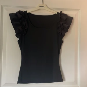 Svart ribbad topp med volangärmar - Supersnygg svart ribbad topp med volangärmar✨