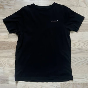 Svart McKenzie t-shirt med tryck - Svart t-shirt från McKenzie med stilrent vitt tryck på bröstet. Klassisk rund hals och korta ärmar. Mjuk och skön bomull som passar perfekt till streetwear eller chill dagar. Enkel design med diskret logga för en clean look.