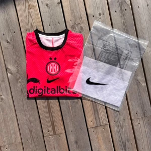 Inter Milan Fotbollströja  - Säljer en riktigt snygg Inter Milan fotbollströja som är i helt nytt skick med etikett, förpackning och är helt oanvänd. Den är i storlek S och är i färgen röd/rosa med svarta detaljer. Pris:349kr men priset är inte hugget i sten. 