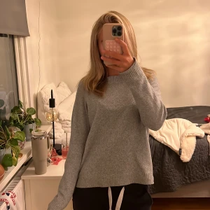 Grå stickad tröja från Vero Moda - Mysig grå stickad tröja från Vero Moda i storlek S. Tröjan har en klassisk rund halsringning, ribbade muddar och en avslappnad passform. Perfekt för kyliga dagar och enkel att matcha med det mesta.