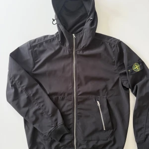 Stone Island jacka - Svart vindjacka från Stone Island med huva och dragkedja framtill. Storlek xl men passar L och M. Den är vattentät och perfekt för regnigt och blåsigt väder. 1200kr, hör av er vid frågor!